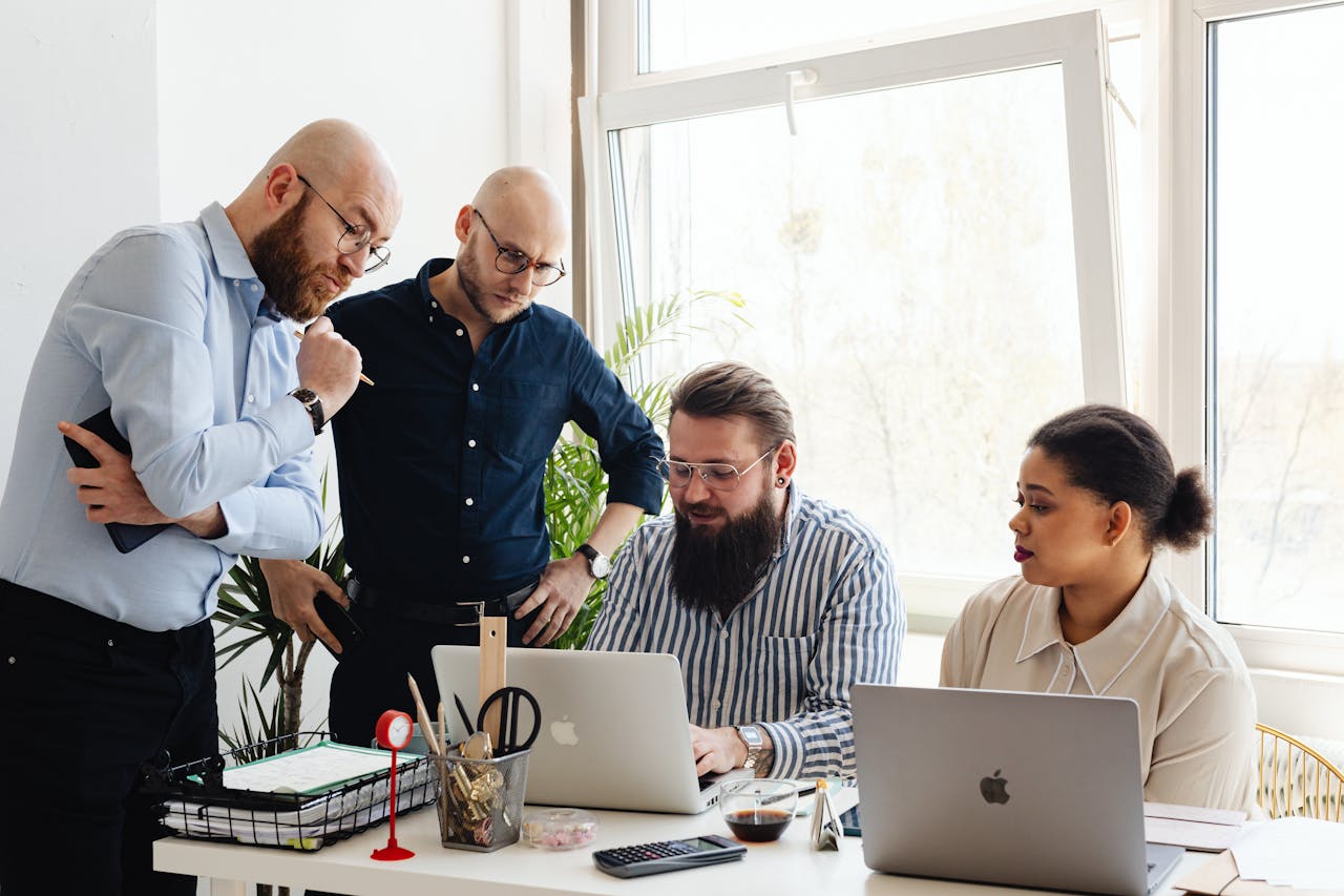 A group of diverse professionals engaged in a collaborative work session in a modern office setting.